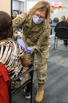 North Carolina National Guard Staff Sgt. Stacie Tindle, a medic assigned to the 130th Maneuver Enhancement Bridge, administers the COVID-19 vaccine to a patient at the Forsyth County Department of Public Health in Winston-Salem, North Carolina, Jan. 12, 2021. Gov. Roy Cooper mobilized the NCNG to support local health providers by augmenting their distribution and vaccination operations.