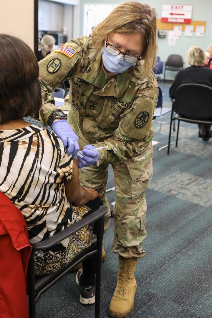 North Carolina National Guard Staff Sgt. Stacie Tindle, a medic assigned to the 130th Maneuver Enhancement Bridge, administers the COVID-19 vaccine to a patient at the Forsyth County Department of Public Health in Winston-Salem, North Carolina, Jan. 12, 2021. Gov. Roy Cooper mobilized the NCNG to support local health providers by augmenting their distribution and vaccination operations.