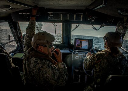 Construction Mechanic 1st Class Lucas Arriaga assigned to Maritime Expeditionary Security Squadron (MSRON) 11, relays course changes aboard a 34-foot Sea Ark patrol boat during a navigation check ride exercise off the coast of Long Beach, Calif.