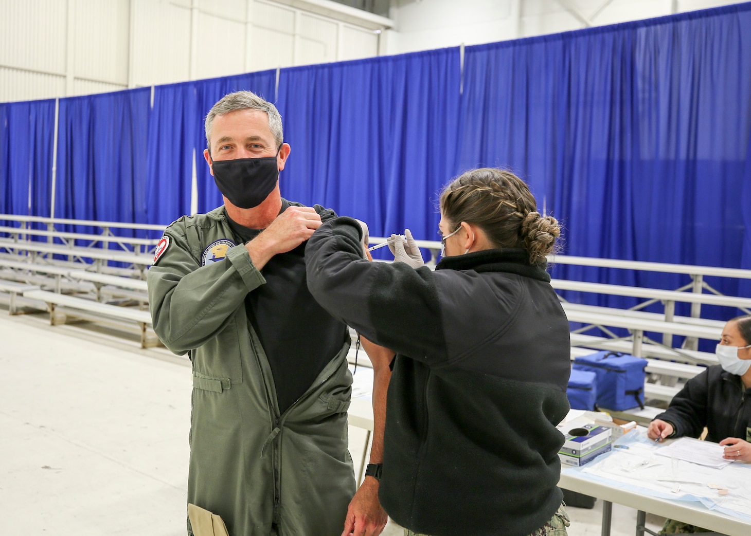 210113-N-PU674-0002 PENSACOLA, Fla. (Jan. 13, 2021) Rear Adm. Pete Garvin, commander, Naval Education and Training Command receives a COVID-19 vaccine from Hospital Corpsman Jordan Vesley at a vaccination event at Naval Air Technical Training Center onboard Naval Air Station Pensacola.  The Department of Defense (DoD) is taking a prioritized, phased approach for administering the vaccine to strengthen the DoD’s ability to protect its people, maintain readiness, and support the national COVID-19 response. (U.S. Navy photo by Carla M. McCarthy)