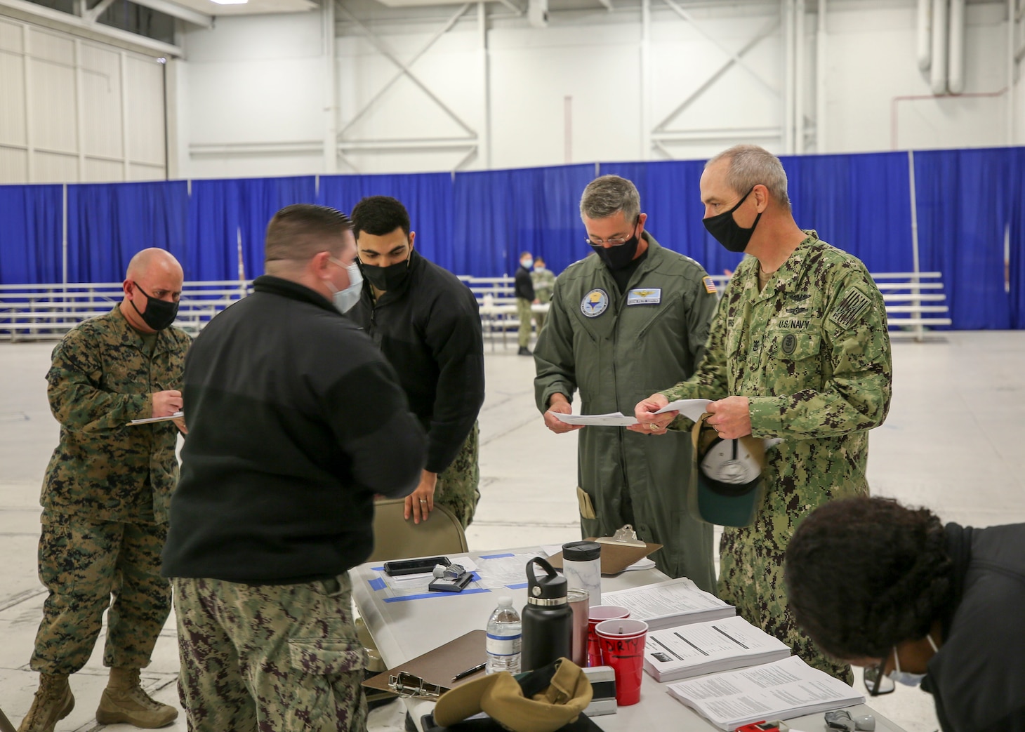 210113-N-PU674-0001 PENSACOLA, Fla. (Jan. 13, 2021) Rear Adm. Pete Garvin, commander, Naval Education and Training Command (NETC), center right, and NETC Force Master Chief Matthew Harris, right, prepare to receive a COVID-19 vaccine at a vaccination event at Naval Air Technical Training Center onboard Naval Air Station Pensacola. The Department of Defense (DoD) is taking a prioritized, phased approach for administering the vaccine to strengthen the DoD’s ability to protect its people, maintain readiness, and support the national COVID-19 response. (U.S. Navy photo by Carla M. McCarthy)