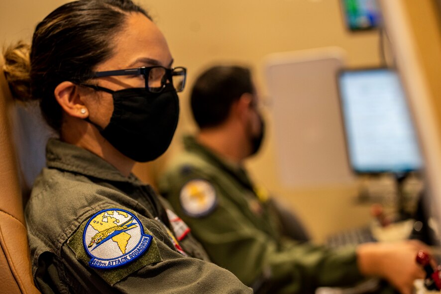 An airman looks at her monitors in a simulator before a training sortie.