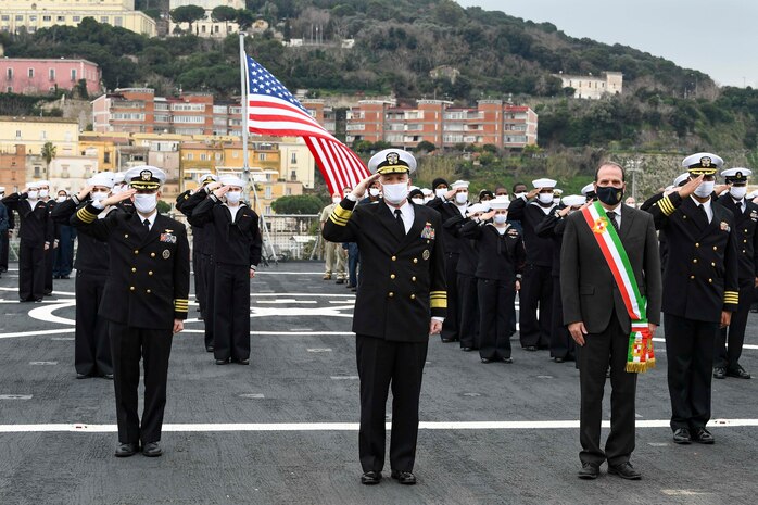 120114-N-XT273-0030 GAETA, Italy (Jan. 14, 2021) Capt. Dave Pollard, USS Mount Whitney commanding officer, left, Vice Adm. Gene Black, Commander, U.S. Sixth Fleet, center, Cosmo Mitrano, Mayor of Gaeta, and the crew of the U.S. Sixth Fleet command and control ship USS Mount Whitney (LCC 20) stand in formation during the ship’s 50th anniversary celebration, Jan. 14, 2021, in Gaeta, Italy. U.S. Sixth Fleet, headquartered in Naples, Italy, conducts the full spectrum of joint and naval operations, often in concert with allied and interagency partners, in order to advance U.S. national interests, security and stability in Europe and Africa. (U.S. Navy photo by Chief Mass Communication Specialist Justin Stumberg/ Released)