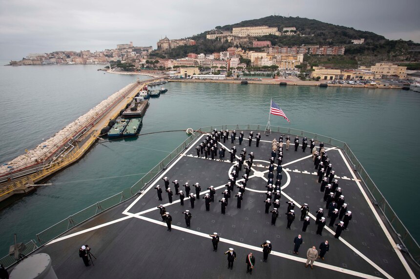 120114-N-NO901-0054 GAETA, Italy (Jan. 14, 2021) The crew of U.S. Sixth Fleet command and control ship USS Mount Whitney (LCC 20) stands in formation during the ship’s 50th anniversary celebration, Jan. 14, 2021, in Gaeta, Italy. U.S. Sixth Fleet, headquartered in Naples, Italy, conducts the full spectrum of joint and naval operations, often in concert with allied and interagency partners, in order to advance U.S. national interests, security and stability in Europe and Africa. (U.S. Navy photo by Hospital Corpsman 2nd Class Jared Kercell/ Released)