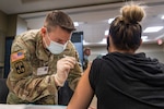 Michigan Army National Guard Sgt. Mark Abbott administers a COVID-19 vaccine to a health care worker at the Ascension Providence Rochester Hospital, Rochester, Michigan, Dec. 21, 2020. The Michigan Army National Guard is part of a nationwide National Guard effort that involves collecting, securing, transporting and – when requested – administering COVID-19 vaccinations.