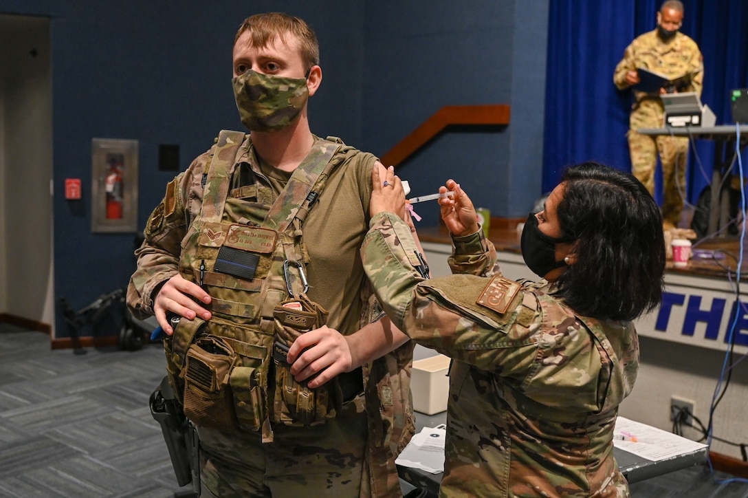 Senior Airman Christian Cardwell, 45th Security Forces Squadron Defender, recieves a COVID-19 vaccine at Patrick Space Force Base, Fla., Jan. 14, 2021. The 45th Medical Group administered the first round of the vaccine in accordance with the Department of Defense's COVID-19 vaccine distribution plan. (U.S. Space Force Photo By Airman First Class Thomas Sjoberg)