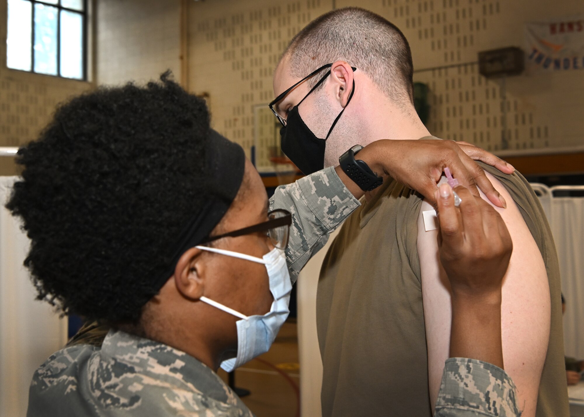 Tech. Sgt. Jordan Swaner, 66th Medical Squadron noncommissioned officer in charge of diagnostic imaging, receives a COVID-19 vaccination from Staff Sgt. Tyler Watkins, 66th Medical Squadron noncommissioned officer in charge of immunizations clinic at Hanscom Air Force Base, Mass., Jan. 14. (U.S. Air Force photo by Todd Maki)