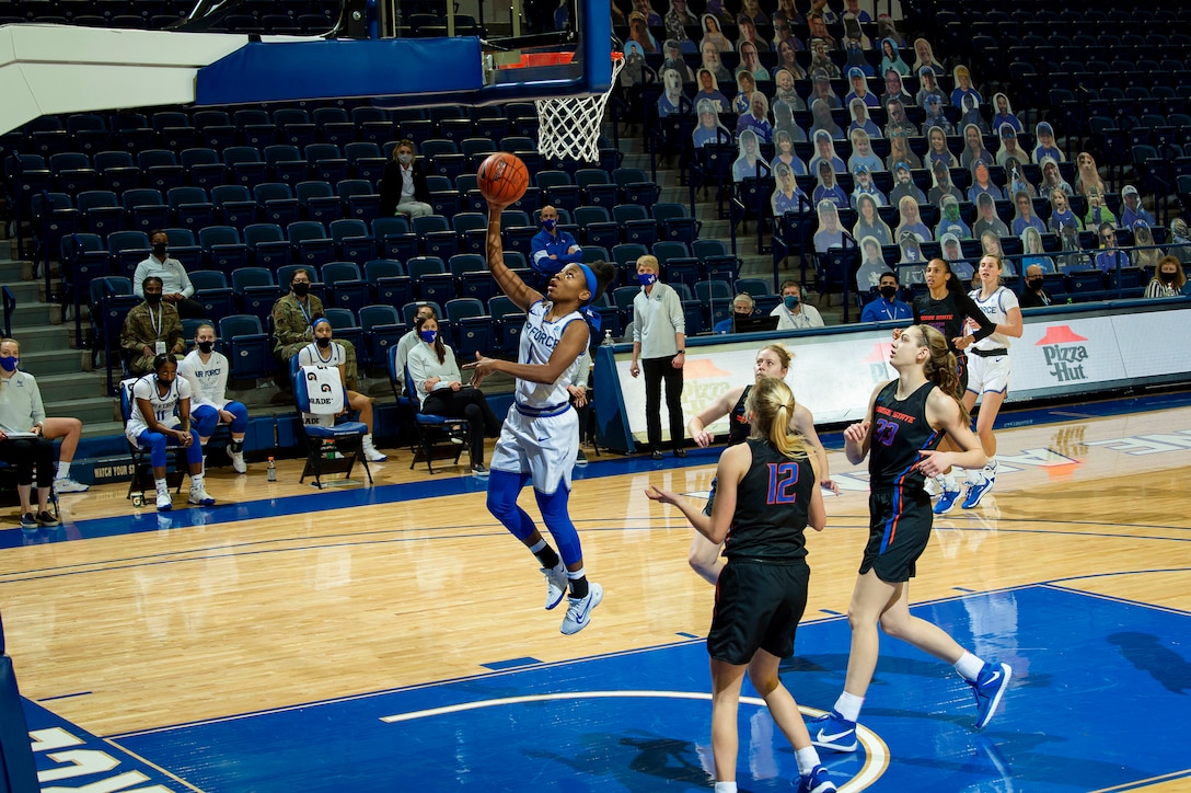 A basketball player attempts a layup during a game.