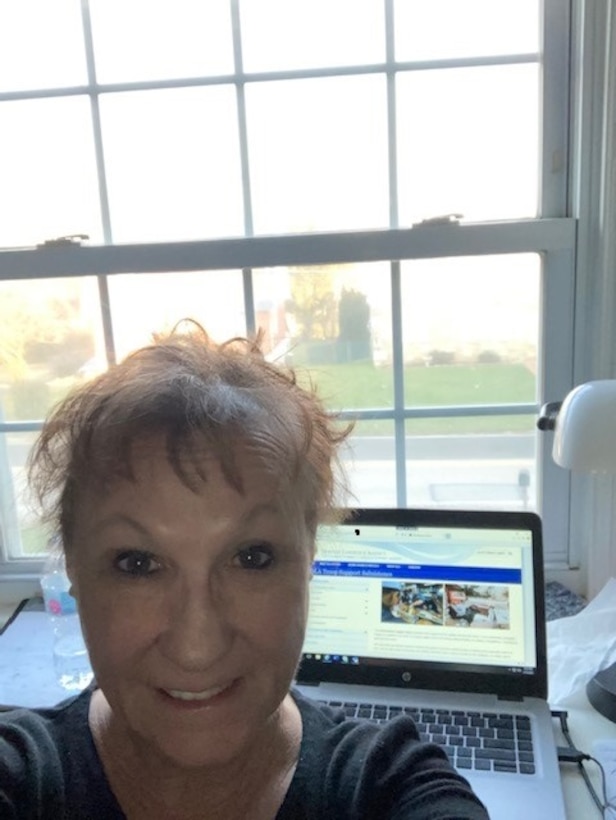 A woman takes a photo with her work computer.