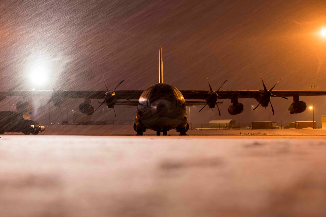 Water sprays onto a parked Marine Corps aircraft.