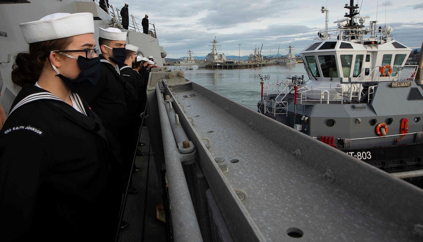 210114-N-FP334-1129 NAVAL STATION EVERETT, Wash. (Jan. 14, 2020) Sailors assigned to the Arleigh Burke-class guided-missile destroyer USS Ralph Johnson (DDG 114) man the rails as the ship pulls into Naval Station Everett, Jan 14. Ralph Johnson returned following a successful deployment to the U.S. 5th Fleet and U.S. 7th Fleet area of operations, which included freedom of navigation operations and participation in Operation Inherent Resolve. (U.S. Navy photo by Mass Communication Specialist 3rd Class Anthony Collier)