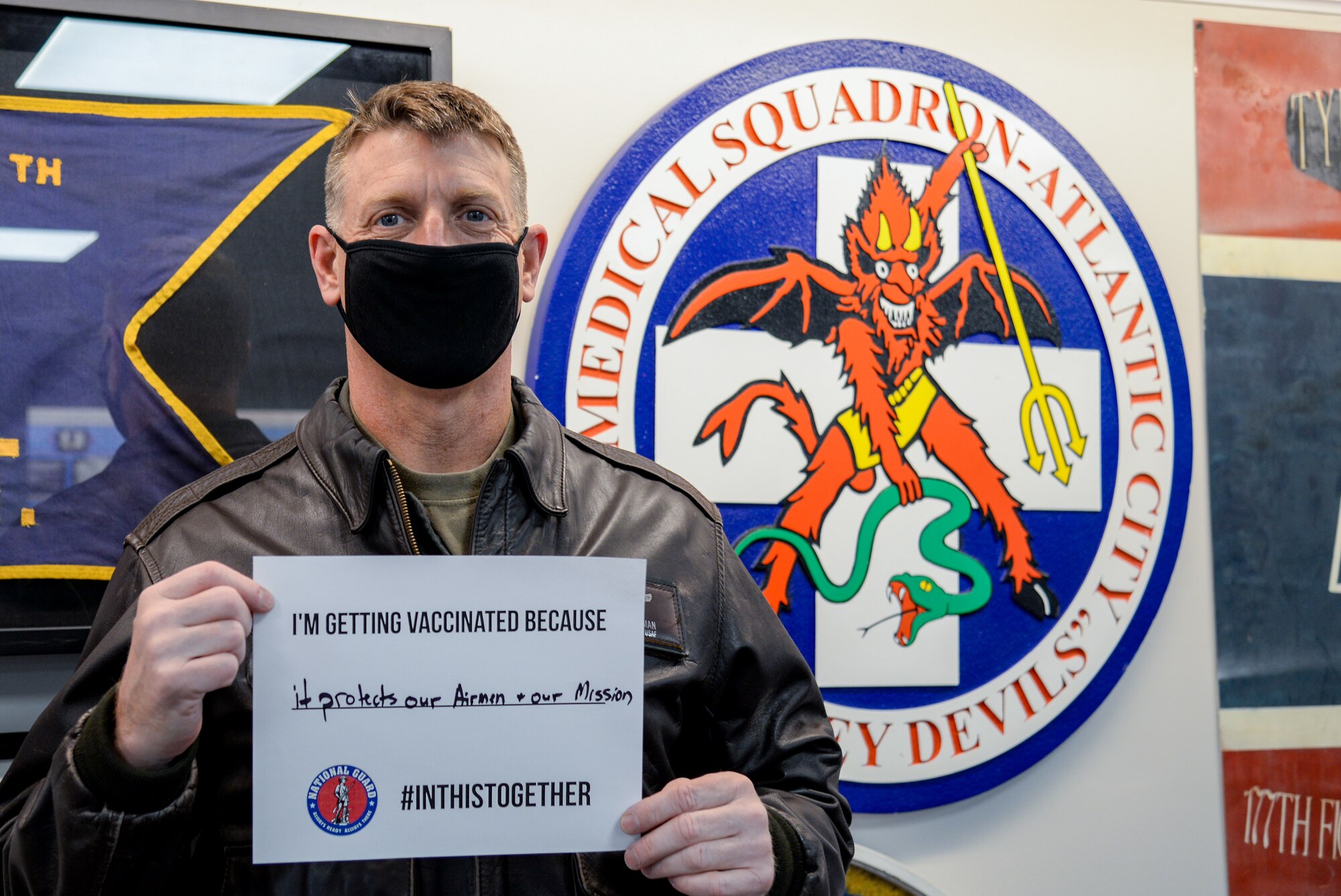 A photo of  Col. Bradford R. Everman holding a sign stating why he received one of the 30 COVID-19 vaccines given at the 177th Fighter Wing.
