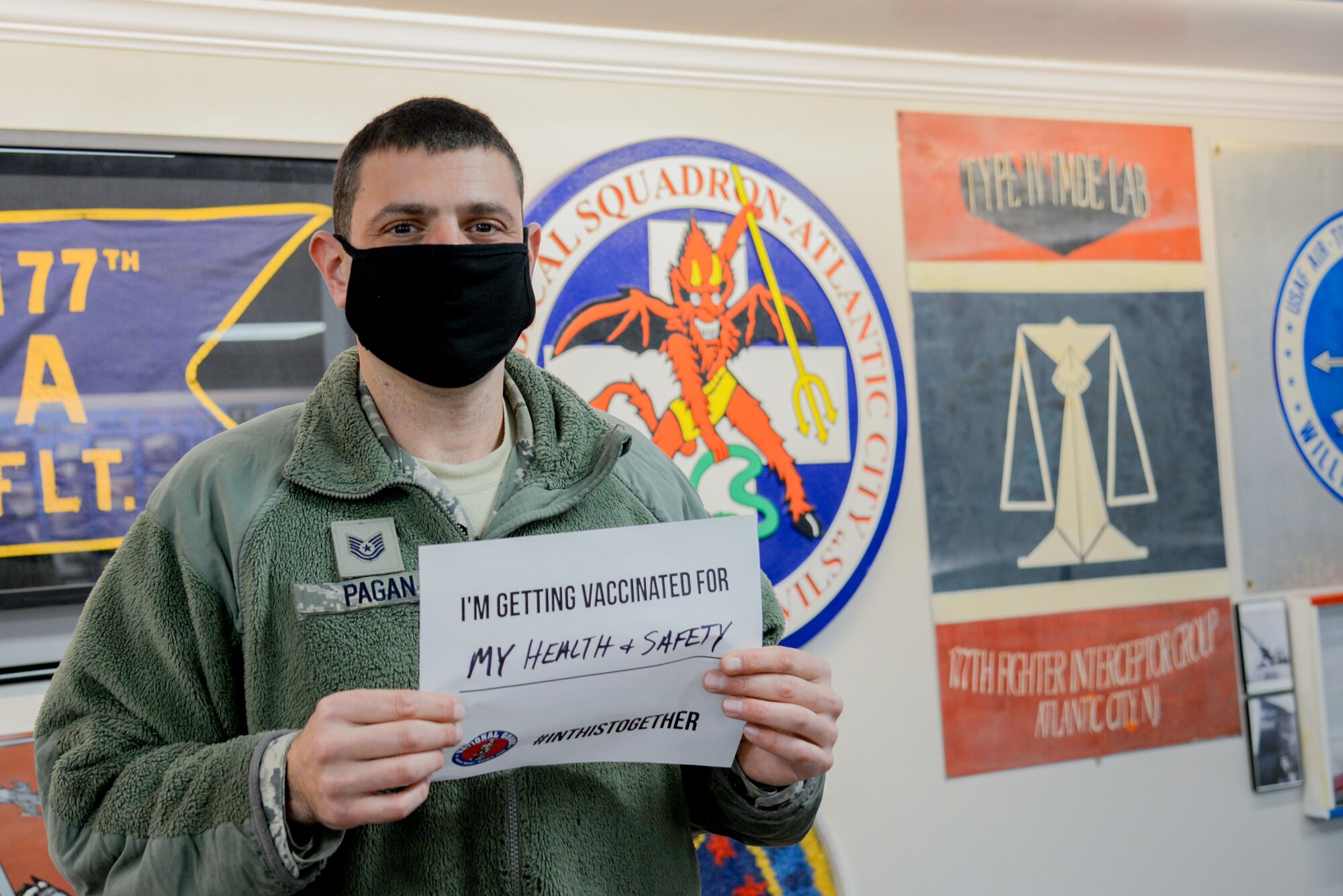 A photo of Tech. Sgt. Jason R. Pagan holding a sign stating why he volunteered to receive a COVID-19 vaccine.