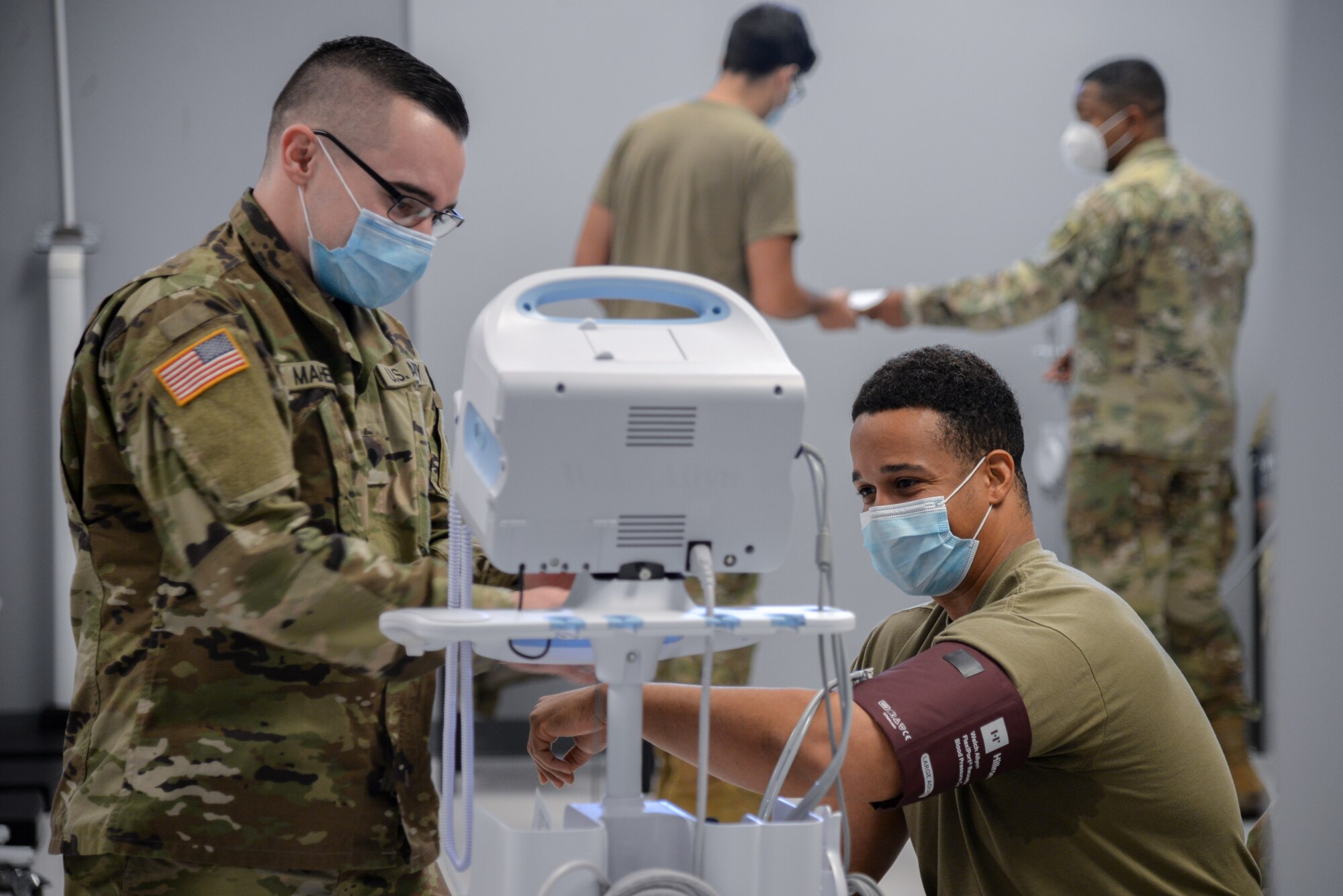 U.S. Army Specialist Matthew Maher, Medical Command medic, observes the blood pressure of U.S. Air Force Tech. Sgt. Miracle Mays, 177th Security Forces Squadron defender Jan. 13, 2021, at the New Jersey National Guard Base, Sea Girt, N.J. The out-process included a briefing, medical examinations and a sit-down with administration. (U.S. Air National Guard photo by Airman 1st Class Hunter Hires)