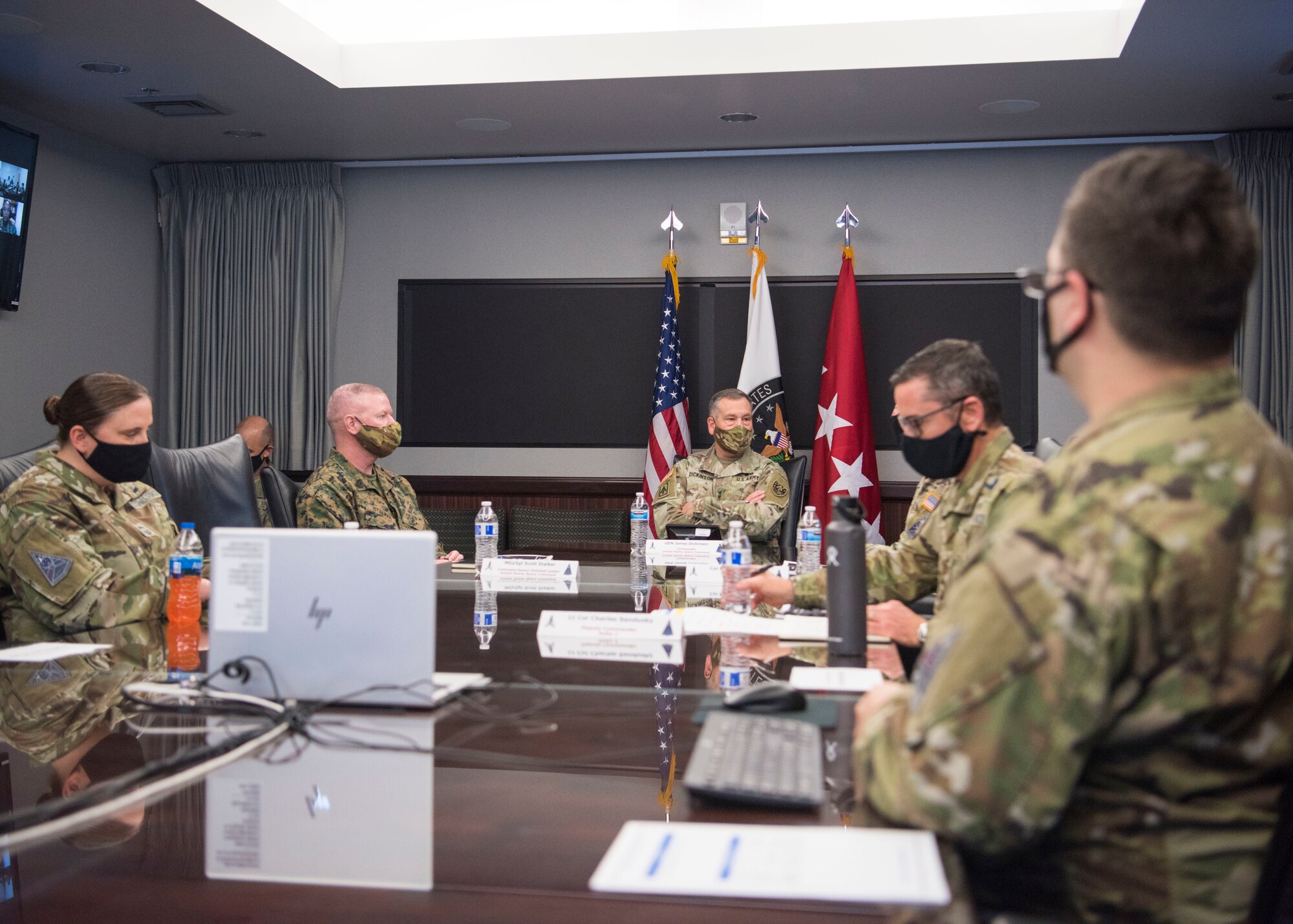 A group of U.S. Space Force personnel sit around a conference table during a briefing.