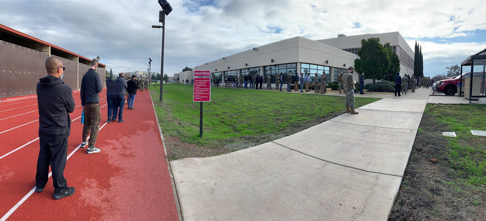 Department of Defense personnel line up to receive the initial dose of the COVID-19 vaccine at the Physical Fitness Center, Travis Air Force Base, California, Jan. 8, 2021. The vaccine requires two doses per person, separated by about four weeks between doses. It is designed to protect personnel against the coronavirus, and officials are encouraging all prioritized personnel to take the vaccine as it becomes available. (U.S. Air Force photo by Heide Couch)