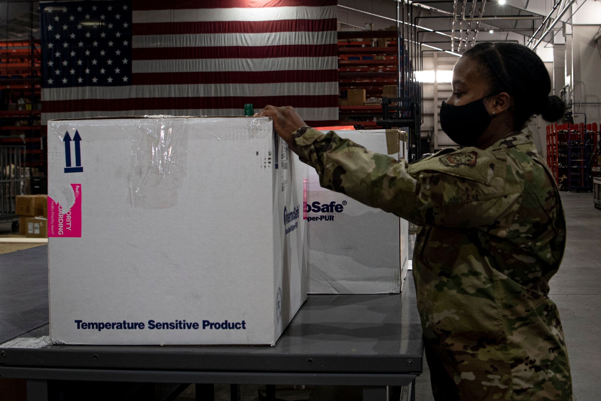 Photo of an Airman labeling a COVID-19 vaccine shipment.