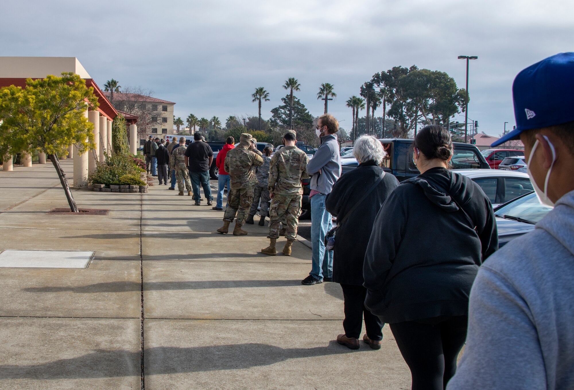 Department of Defense personnel line up to receive the initial dose of the COVID-19 vaccine at the Physical Fitness Center, Travis Air Force Base, California, Jan. 8, 2021. The vaccine requires two doses per person, separated by about four weeks between doses. It is designed to protect personnel against the coronavirus, and officials are encouraging all prioritized personnel to take the vaccine as it becomes available. (U.S. Air Force photo by Heide Couch)