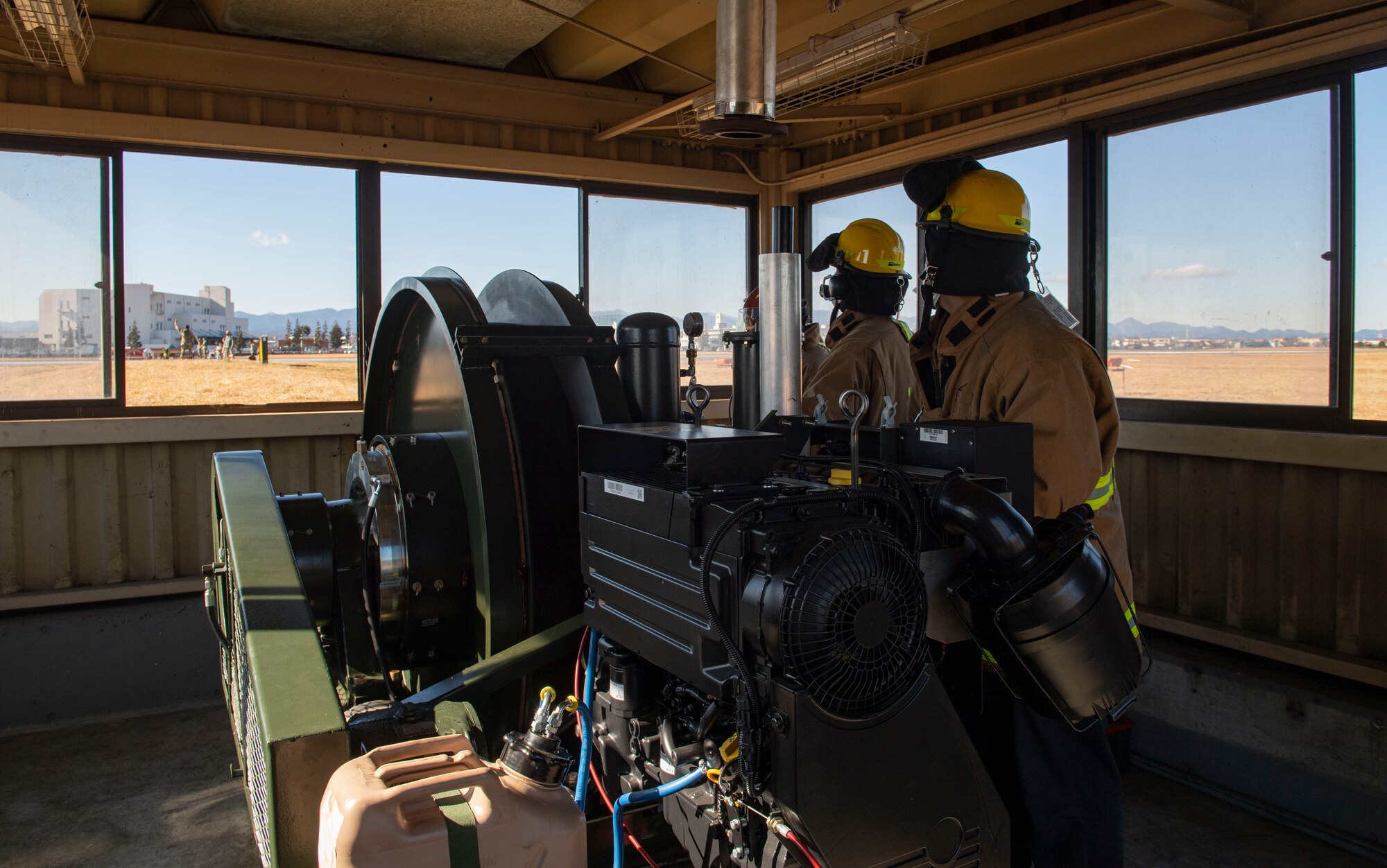 Fire fighters assigned to the 374th Civil Engineer Squadron fire department, operate the newly installed flightline BAK-12 barrier, aircraft arresting system (AAS)