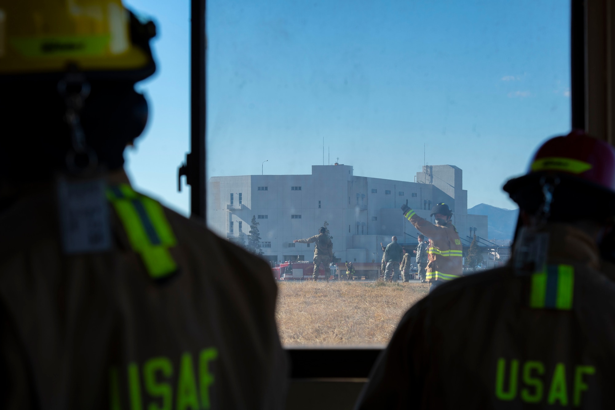 Fire fighters assigned to the 374th Civil Engineer Squadron fire department, are given hand signals while they operate the newly installed flightline BAK-12 barrier