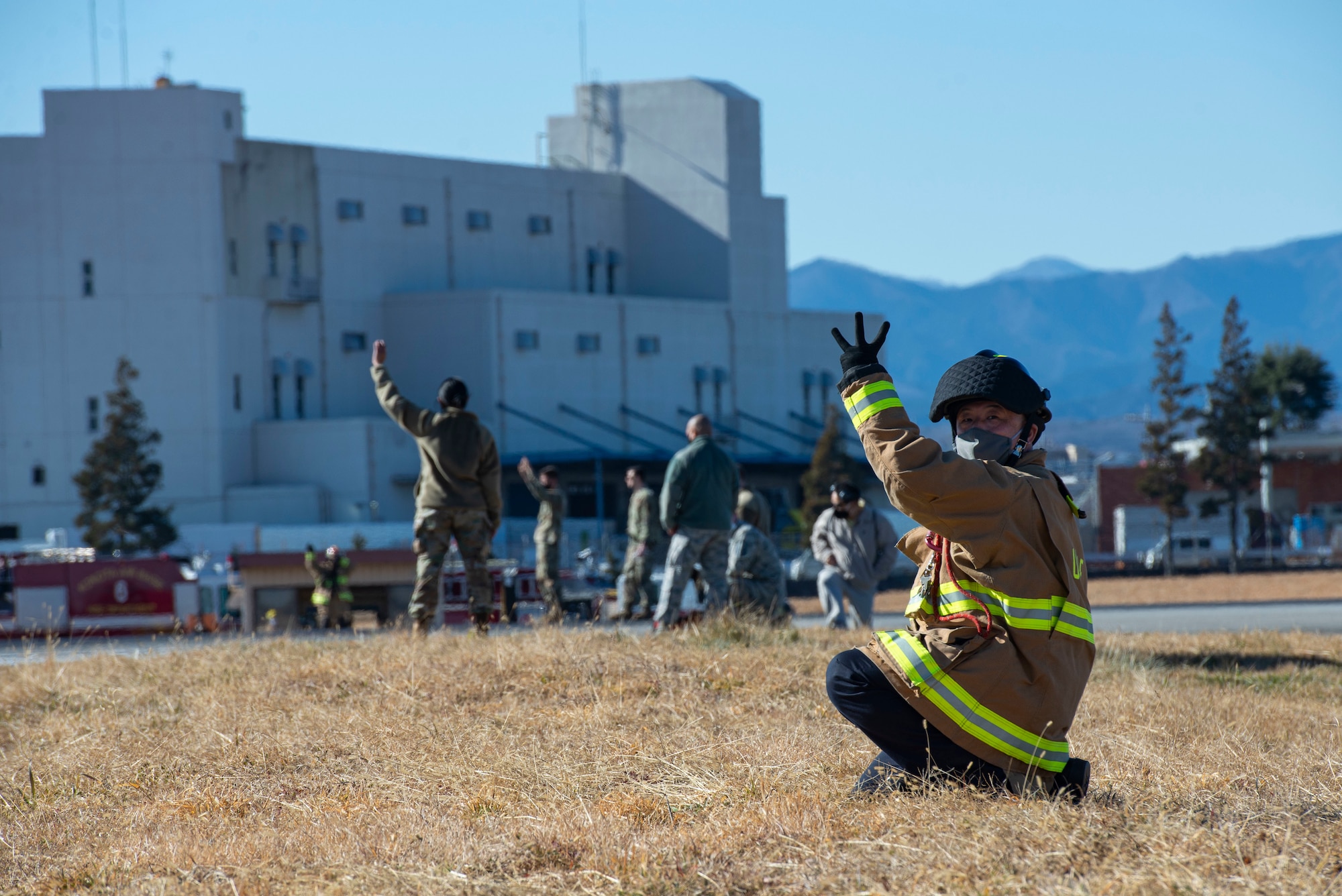 A fire fighter assigned to the 374th Civil Engineer Squadron fire department, gives hand signals to the newly installed flightline BAK-12 barrier, aircraft arresting system (AAS) operators