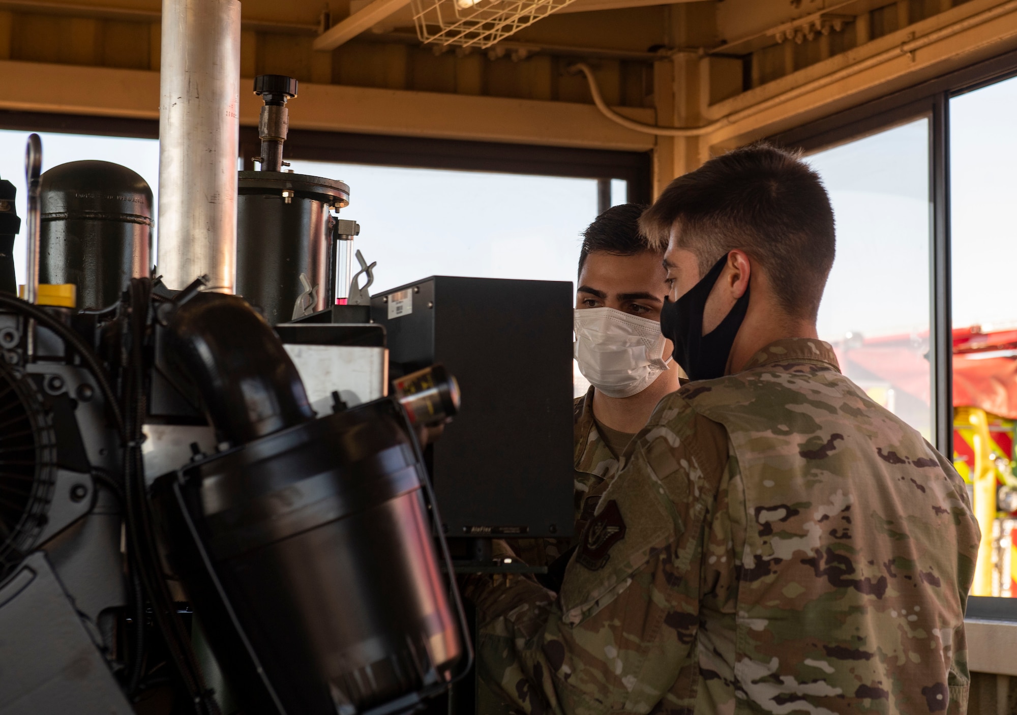 Staff Sgt. Zach Sheller, 374th Civil Engineer Squadron electrical power productions shop craftsman, left, trains Airman Eric Christenson, 374th CES electrical power productions shop apprentice, on how to correctly operate the newly installed flightline BAK-12 barrier, aircraft arresting system (AAS)