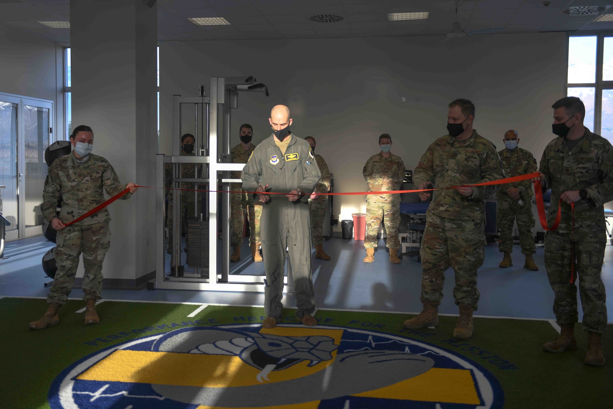 U.S. Air Force Brig. Gen. Jason E. Bailey, 31st Fighter Wing commander, participates in a ribbon-cutting ceremony at the Comprehensive Operational Medicine for Battle Ready Airmen (COBRA) Clinic with Airmen from the 31st Medical Group at Aviano Air Base, Italy, Jan. 14, 2021. The COBRA clinic is a newly innovated program unique to Aviano and designed to focus on readiness by preventing or reducing mental health and musculoskeletal profiles of our Airmen. The COBRA clinic is based on a hub and spoke model of care incorporating diagnosis, recovery, rehabilitation, and performance optimization into a single unified mission. (U.S. Air Force photo by Senior Airman Ericka A. Woolever)