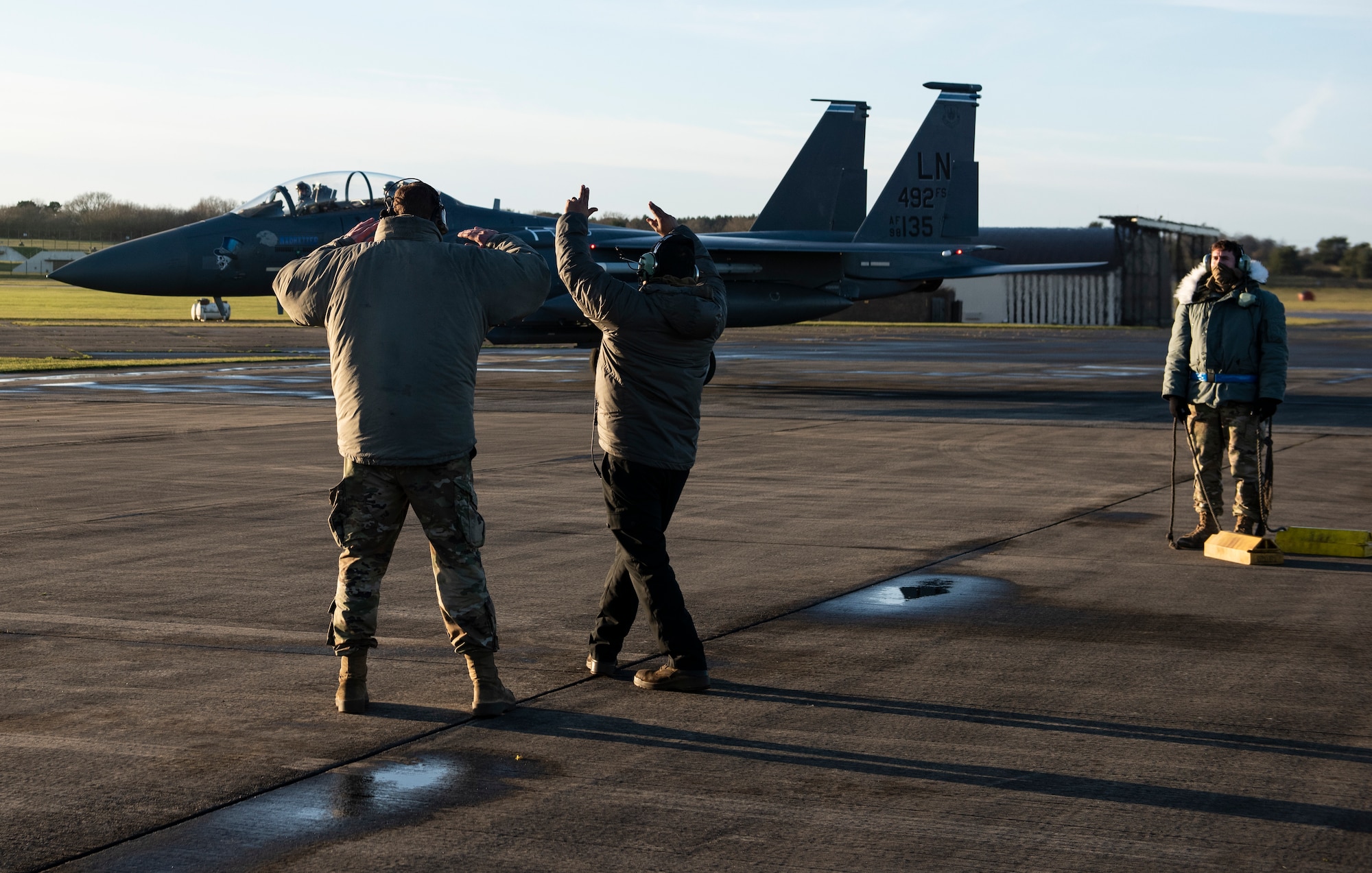 U.S. Air Force Airmen from the 48th Aircraft Maintenance Squadron direct an F-15E Strike Eagle onto the apron during Agile Combat Employment training at Royal Air Force Lakenheath, England, Jan. 12, 2021. Agile Combat Employment capabilities ensure U.S. Air Forces in Europe, along with allies and partners, are ready for potential last minute contingencies by allowing forces to operate from locations with varying levels of capacity and support. (U.S. Air Force photo by Airman 1st Class Jessi Monte)