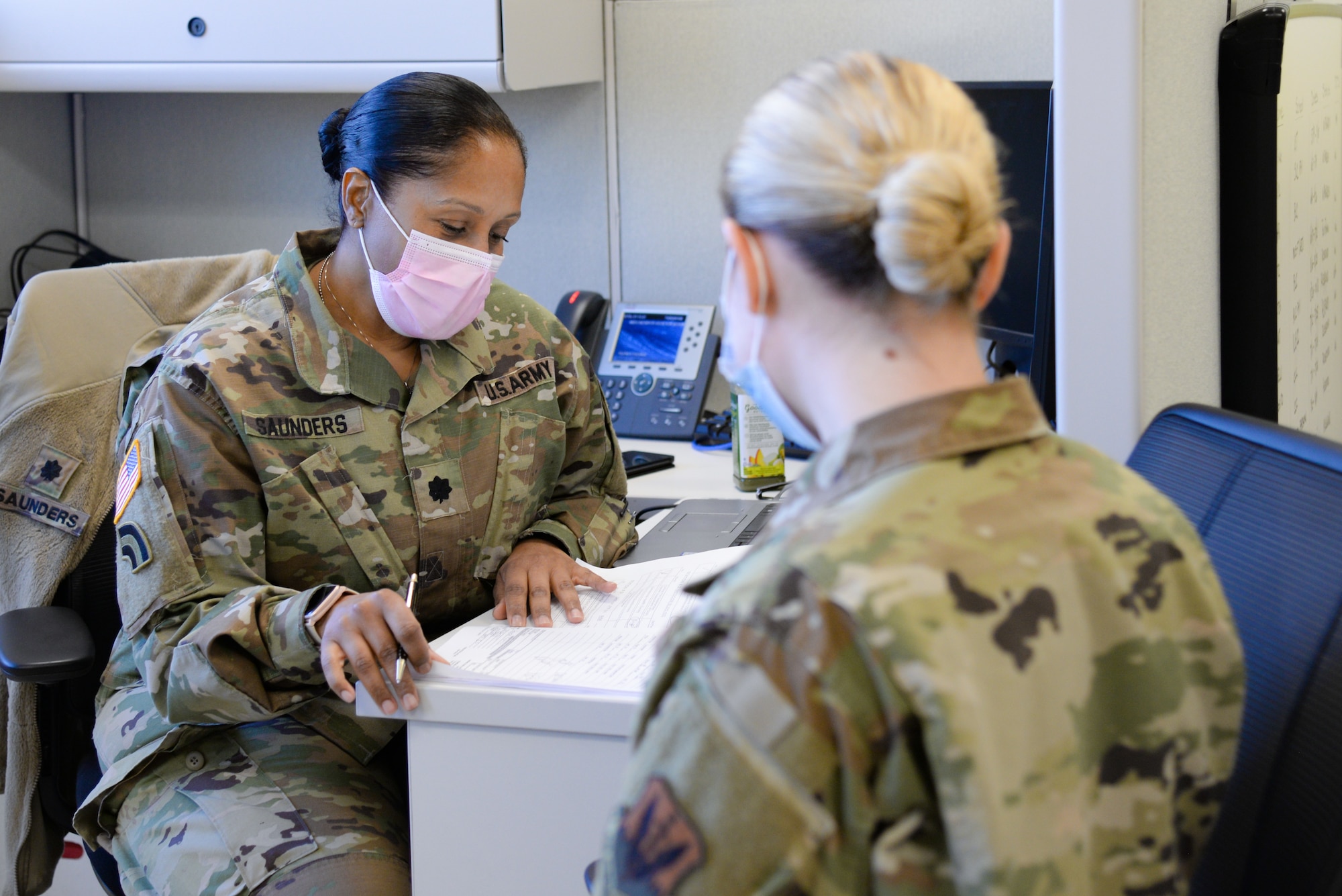 U.S. Army Lt. Col. Lorraine Saunders, 44th Infantry Brigade Combat Team brigadier surgeon, left, reviews the paperwork of U.S. Air Force Airman lauren A. Paduani, 177th Logistics Readiness Squadron traffic management office specialist, Jan. 13, 2021, at the New Jersey National Guard Base, Sea Girt, N.J. The out-process included a briefing, medical examinations and a sit-down with administration. (U.S. Air National Guard photo by Airman 1st Class Hunter Hires)