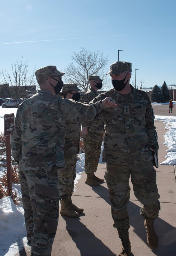 Two Space Force military members bump elbows in greeting.