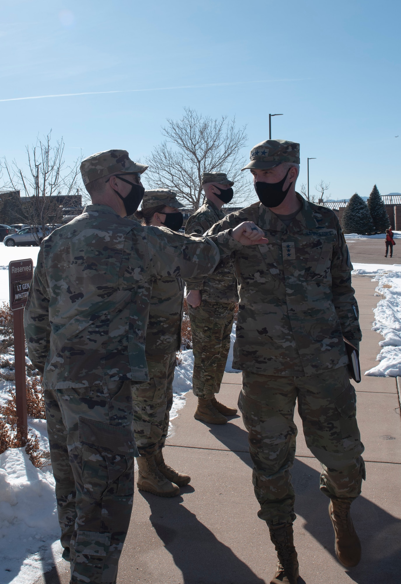 Two Space Force military members bump elbows in greeting.