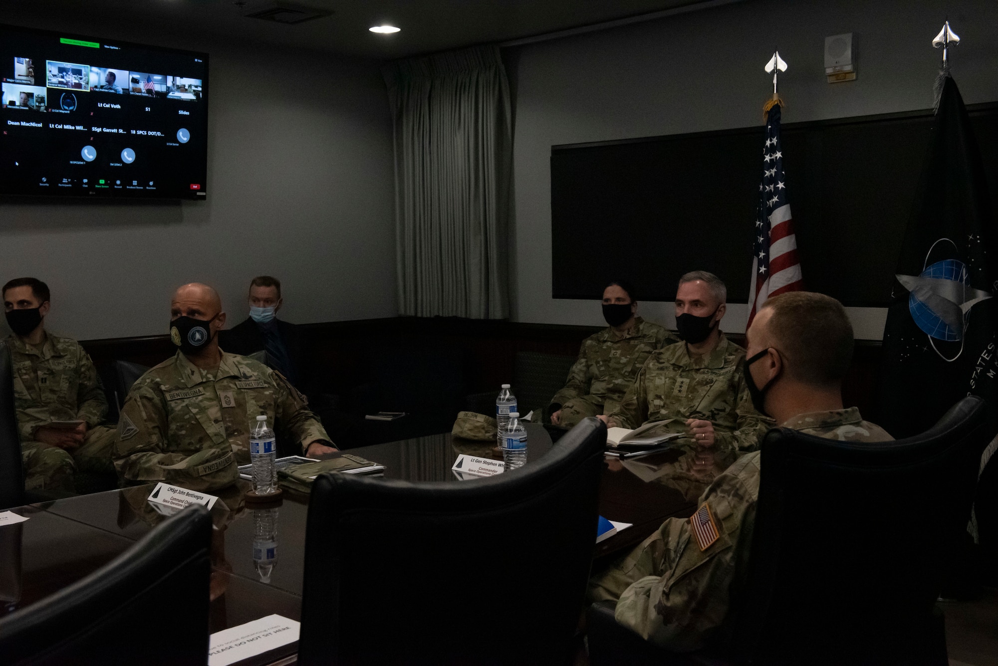 Group of Space Force personnel sitting at conference table during a briefing.