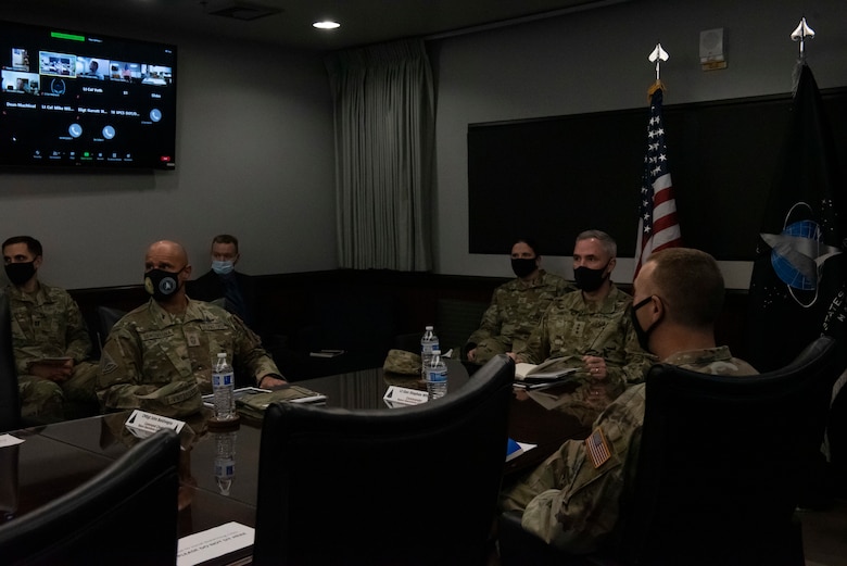 Group of Space Force personnel sitting at conference table during a briefing.