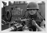 Coast Guard Gunner's Mate William "Bill" Wells, II, mans one of CGC POINT GLOVER's .50 caliber machine guns for a Navy photographer during the turnover of the cutter to the South Vietnamese Navy in the fall of 1969 in DaNang, South Vietnam.