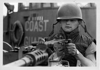 Coast Guard Gunner's Mate William "Bill" Wells, II, mans one of CGC POINT GLOVER's .50 caliber machine guns for a Navy photographer during the turnover of the cutter to the South Vietnamese Navy in the fall of 1969 in DaNang, South Vietnam.