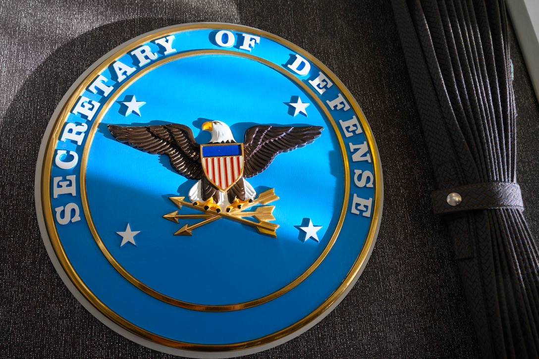 The Secretary of Defense seal is displayed on the inside of a plane.