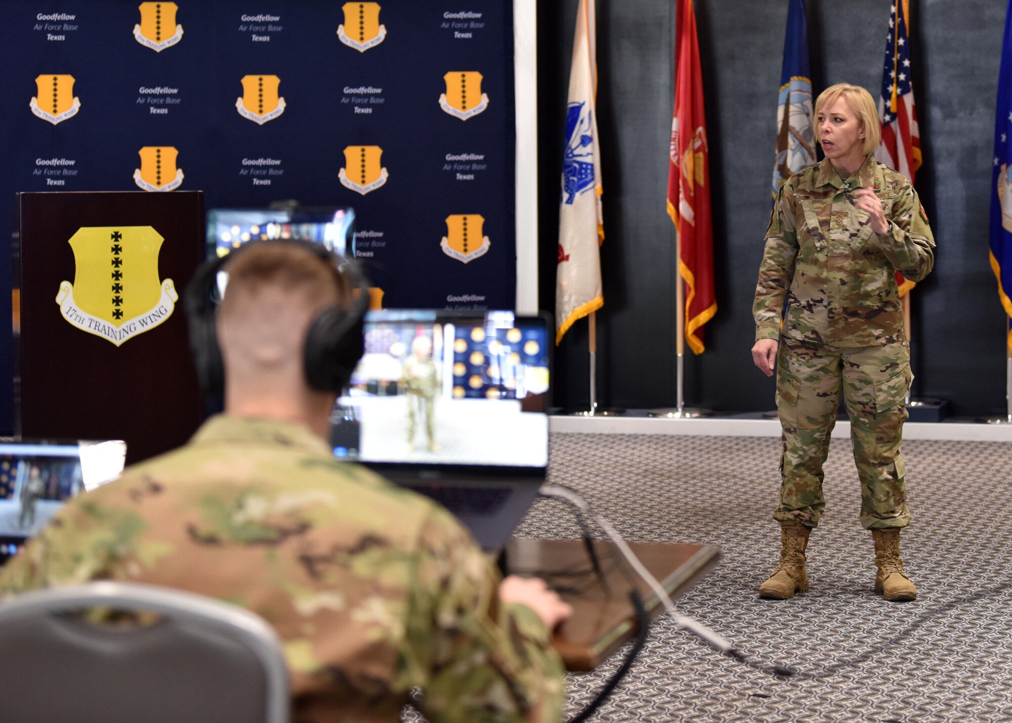 U.S. Air Force Chief Master Sgt. Casy Boomershine, 17th Training Wing command Chief, addresses members of the 17th TRW over a video call and in person during the wing’s first commander’s call of 2021, at the Event Center on Goodfellow Air Force Base, Texas, Jan. 15, 2021. Boomershine discussed the Challenge aspect of the new focus Accelerate, Challenge and Thrive. (U.S. Air Force photo by Staff Sgt. Seraiah Wolf)
