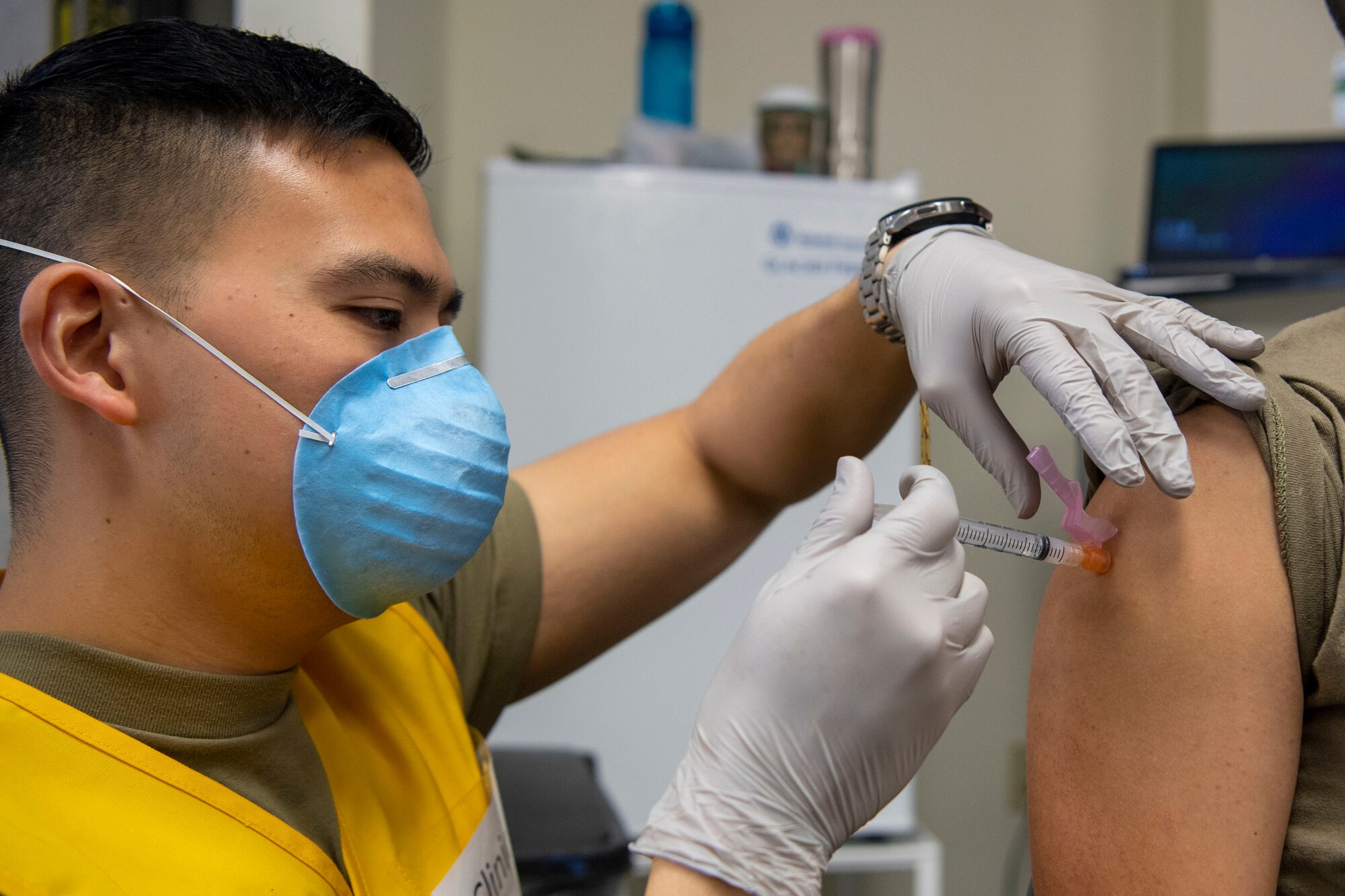 A medical technician administers a COVID-19 vaccine to an airman.
