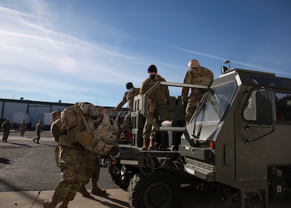 Soldiers load bags.