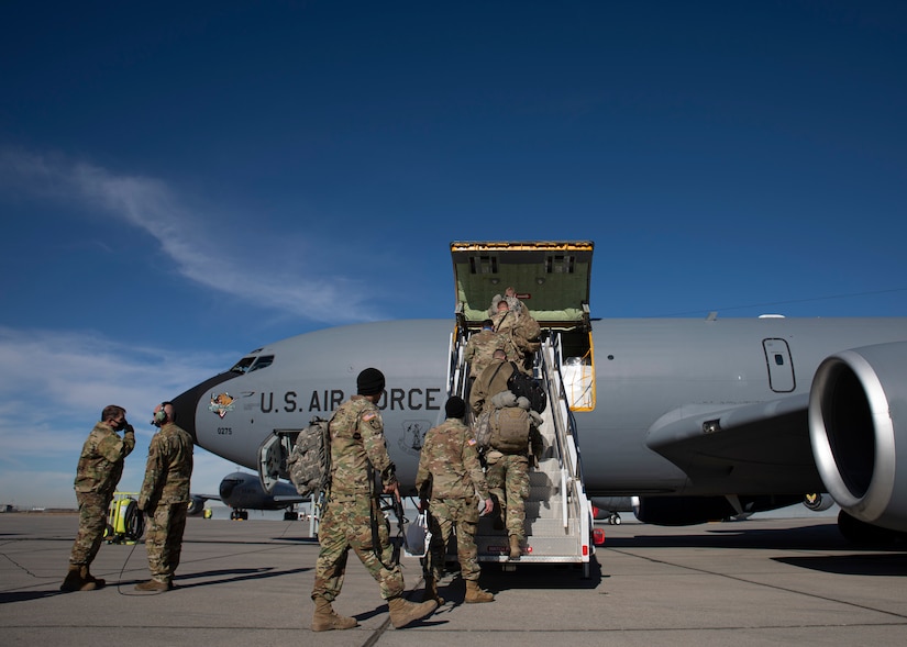 Soldiers walk up stairs to plain.