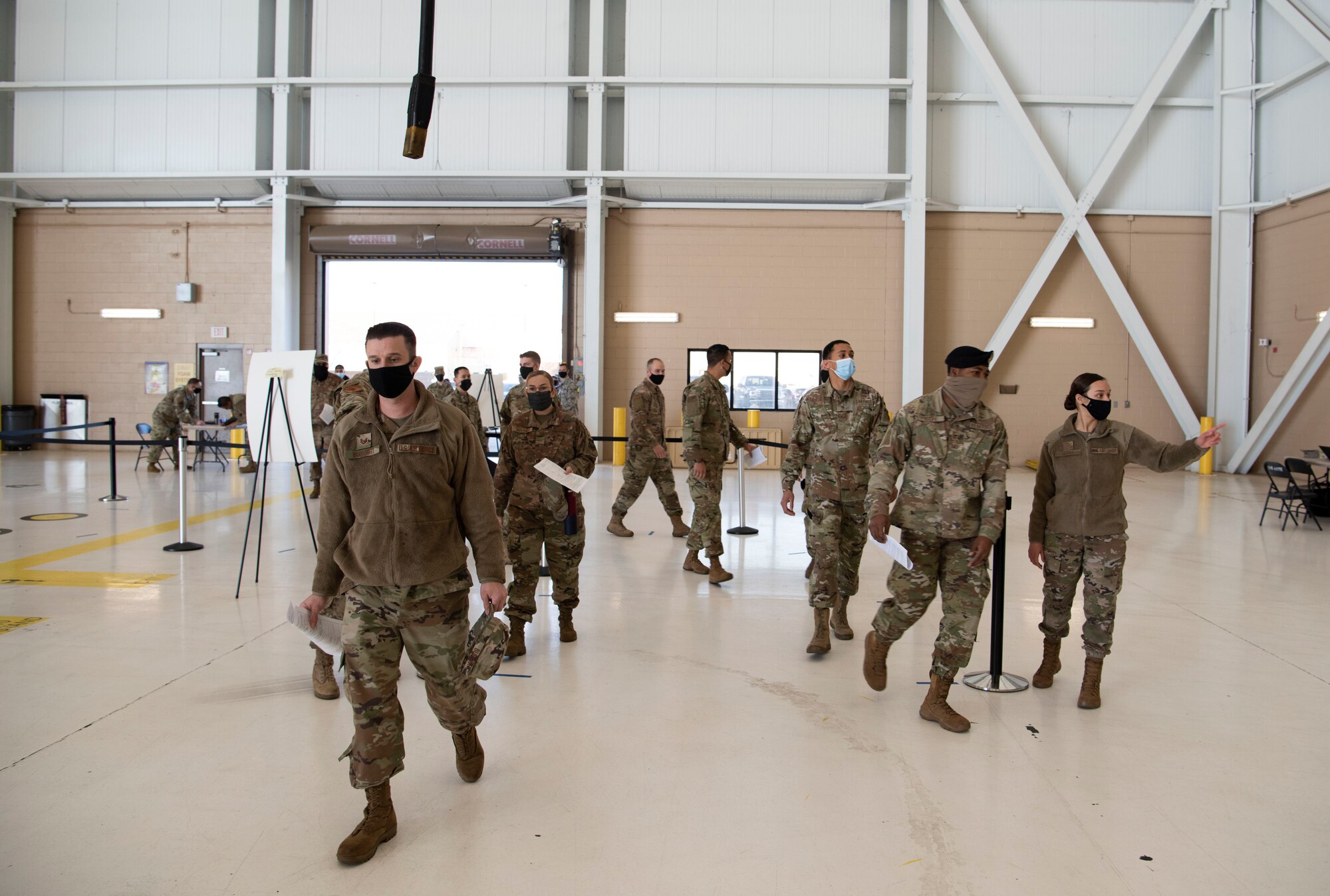 U.S. Airmen arrive at the influenza vaccine point of distribution in a hangar Jan. 14, 2021, at Travis Air Force Base, California. The POD is an organized way of efficiently distributing a vaccine to a large amount of people and preparing medical personnel for future large-scale distributions such as the COVID-19 vaccine. (U.S. Air Force photo by Airman 1st Class Alexander Merchak)