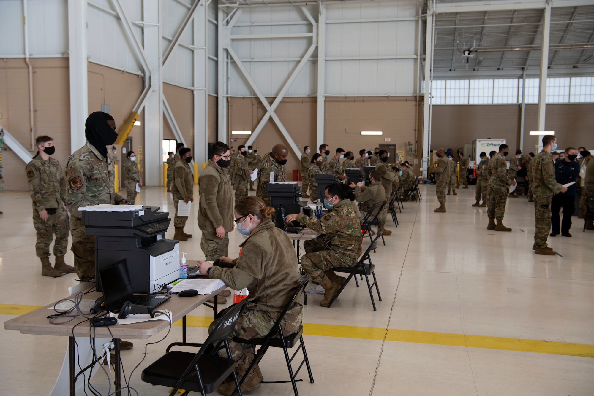 U.S. Airmen from the 60th Medical Group check in military personnel at the influenza vaccine point of distribution in a hangar Jan. 14, 2021, at Travis Air Force Base, California. The POD is an organized way of efficiently distributing a vaccine to a large amount of people and preparing medical personnel for future large-scale distributions such as the COVID-19 vaccine. (U.S. Air Force photo by Airman 1st Class Alexander Merchak)