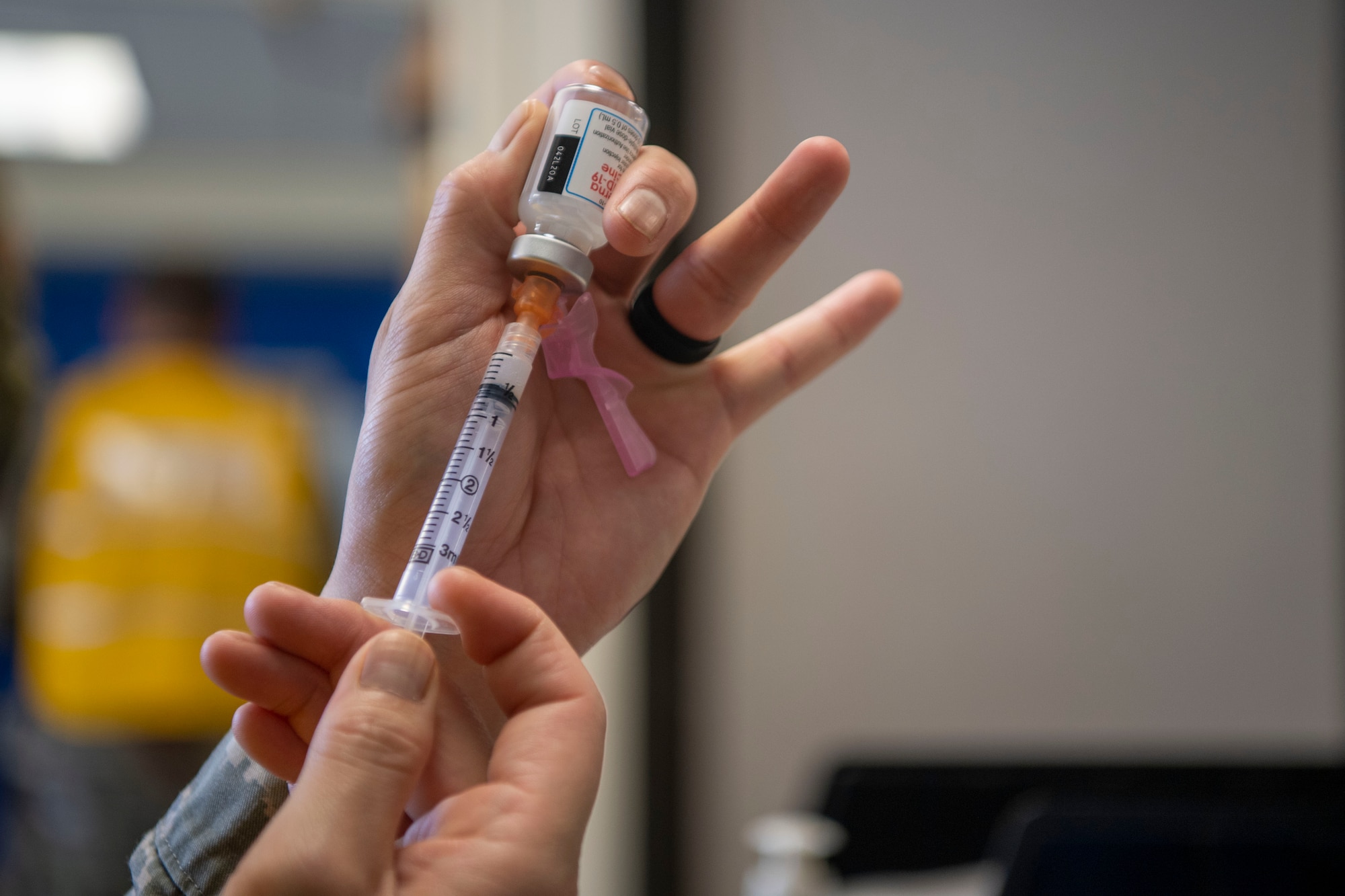 A medical technician draws a dose of the COVID-19 vaccine.