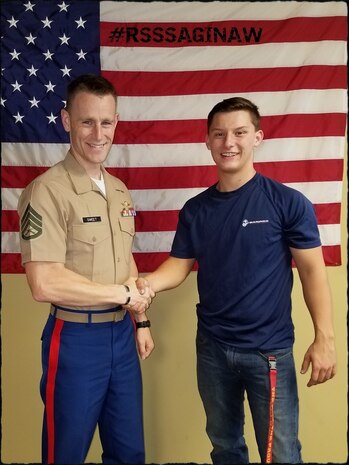 U.S. Marine Staff Sgt. Jonathon Sweet, the staff noncommissioned officer in charge of Recruiting Substation Northern Michigan, congratulates a newly enlisted Marine Corps poolee on his enlistment, Nov. 11, 2018.