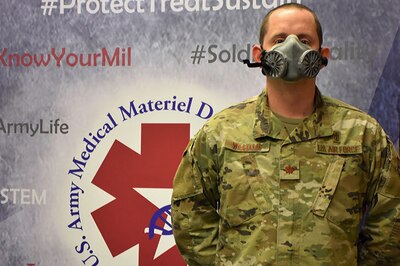 An airman demonstrates the fit of an N95 respirator.