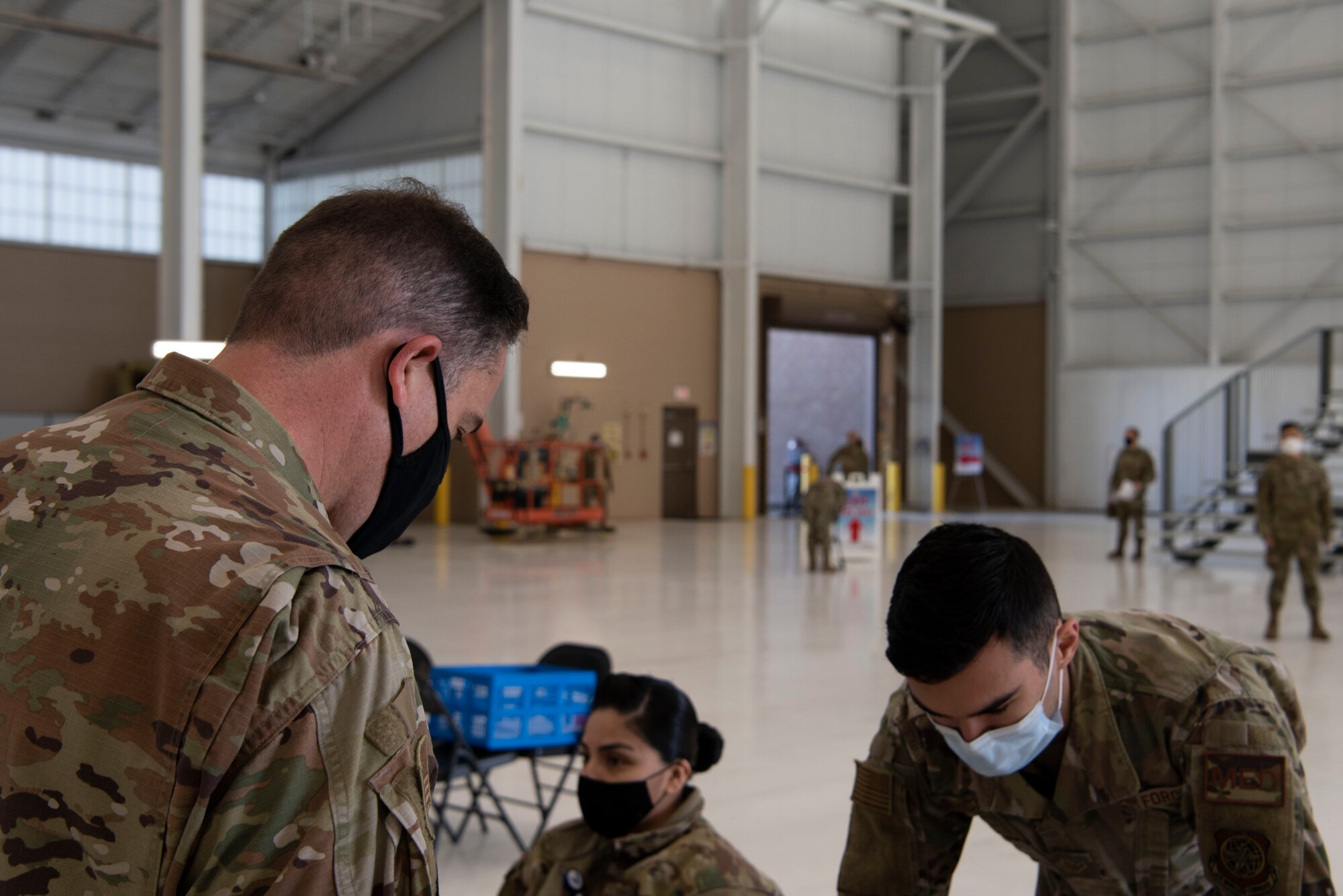 U.S. Air Force Airman 1st Class Tyler Lancaster, 60th Healthcare Operations Squadron medical technician, facilitates patient check out for Lt. Col. Glenn Cameron, 60th Civil Engineering Squadron commander, after Cameron received the influenza vaccine at the point of distribution in a hangar Jan. 14, 2021, at Travis Air Force Base, California. The POD is an organized way of efficiently distributing a vaccine to a large amount of people and preparing medical personnel for future large-scale distributions such as the COVID-19 vaccine. (U.S. Air Force photo by Airman 1st Class Alexander Merchak)