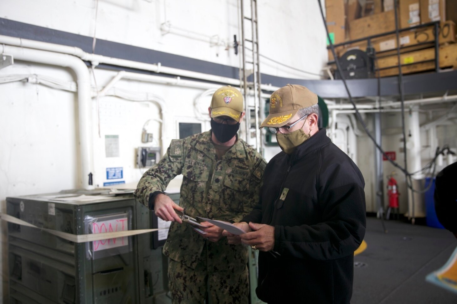 Rear Adm. Robert Katz, commander, Expeditionary Strike Group (ESG 2), reviews paperwork aboard the amphibious transport dock ship USS San Antonio (LPD 17) before receiving the COVID-19 vaccination, Jan. 11, 2021.