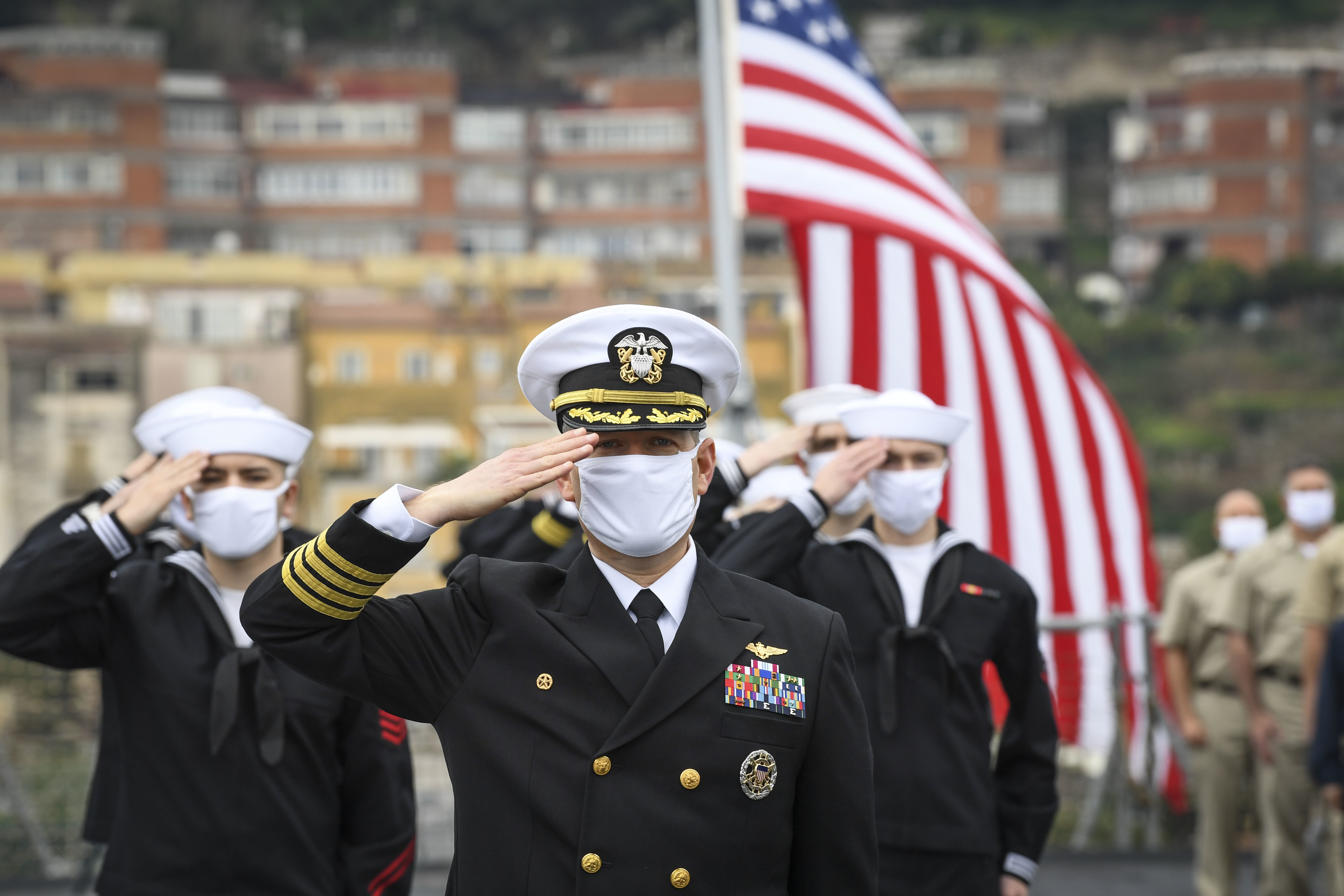 Capt. Dave Pollard, USS Mount Whitney commanding officer, and the crew of U.S. 6th Fleet command and control ship USS Mount Whitney (LCC 20) salute during the ship's 50th anniversary celebration crew photo, Jan. 14, 2021, in Gaeta, Italy.