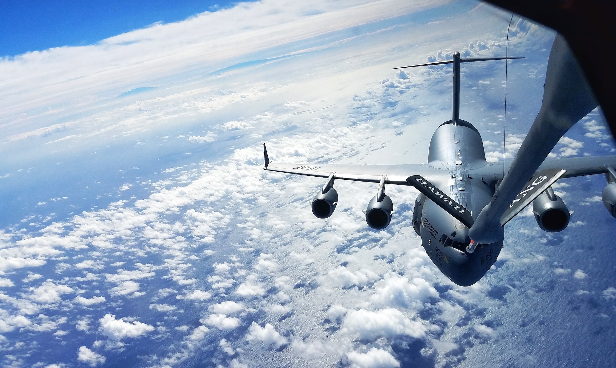 535th Airlift Squadron C-17 Globemaster III, assigned to Joint Base Pearl Harbor-Hickam, HI, receives aerial refueling from 203rd Air Refueling Squadron KC-135 Stratotanker during a local training flight around the islands of Hawaii on February 14, 2018. (U.S. Air Force Photo by Senior Airman Michael Reeves Jr.)