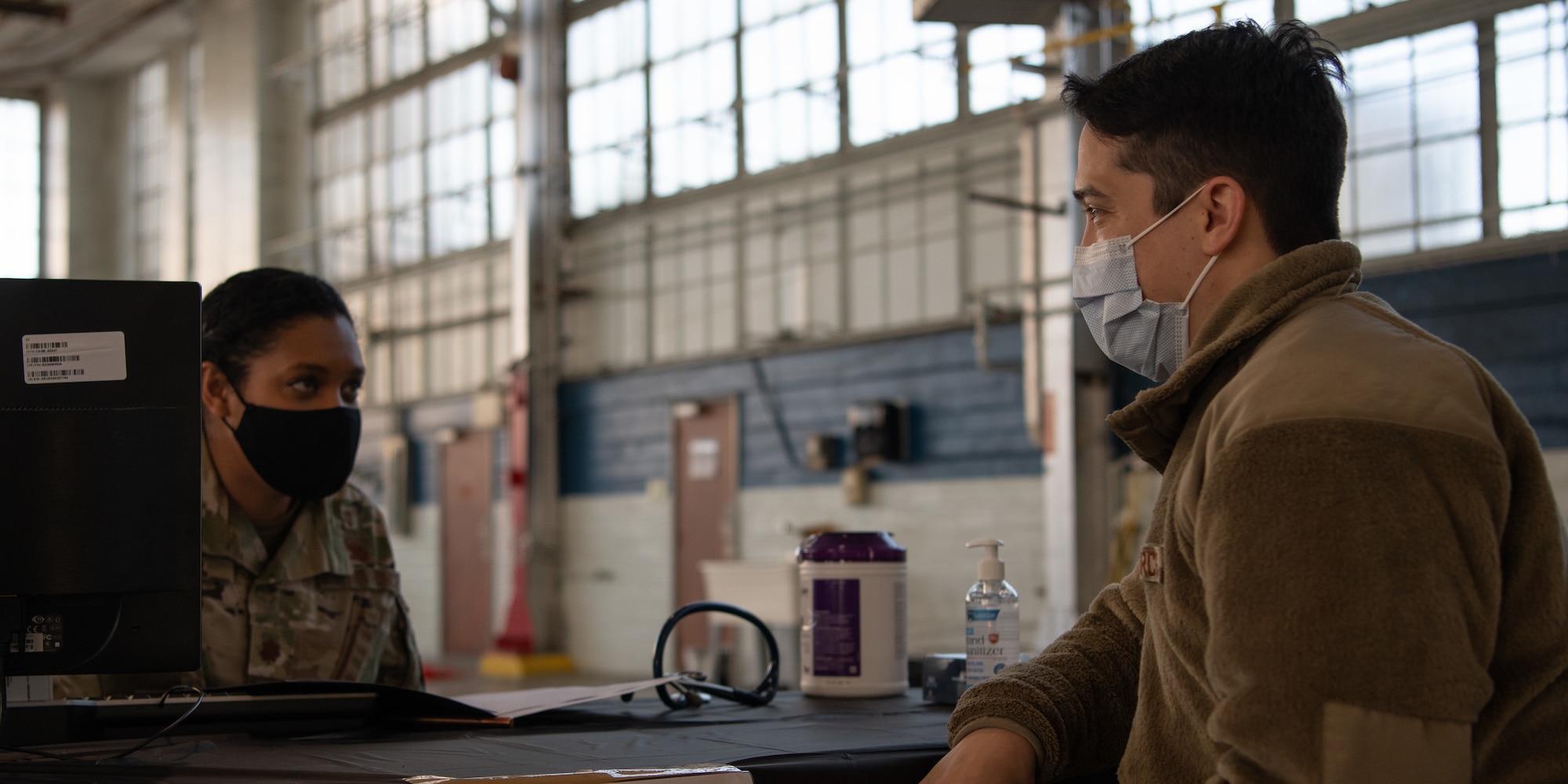 Maj. Shari Hafner, a general medical officer with the 42nd Medical Group, speaks with Staff Sgt. Gabriel Fox, a functional analyst with materiel management on Gunter Annex Jan. 16, 2020, at the off-site clinic in the Honor Guard hangar on Maxwell Air Force Base, Alabama. Hafner screens patients by reviewing their medical history, asking if they’re on any medication and answering their questions about the vaccine to ensure that they can be vaccinated safely and that they feel confident about receiving the vaccine.